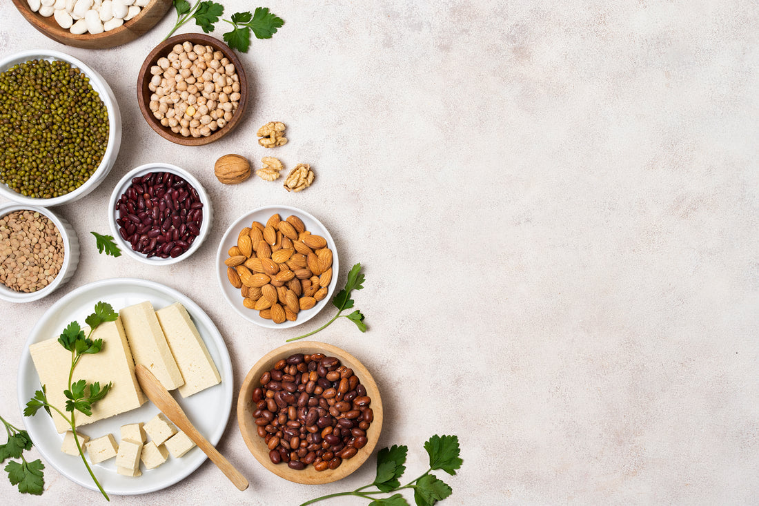Assorted plant-based proteins including tofu, beans, lentils, chickpeas, and nuts.