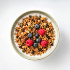 Mena Granola with fresh blueberries and raspberries in a yogurt bowl.